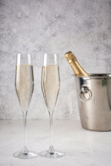 Two glasses of champagne with a champagne bottle in a bucket