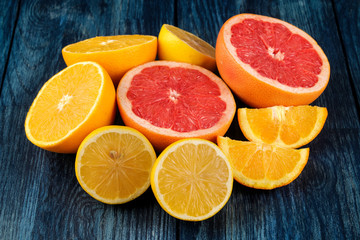 Citrus fruit. Different citrus fruits with leaves of lemon, orange, grapefruit on a blue wooden table.