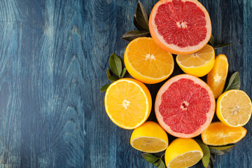 Citrus fruit. Different citrus fruits with leaves of lemon, orange, grapefruit on a blue wooden table. top view