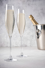 Two glasses of champagne with a champagne bottle in a bucket