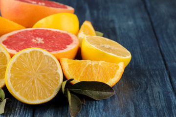 Citrus fruit. Different citrus fruits with leaves of lemon, orange, grapefruit on a blue wooden table.