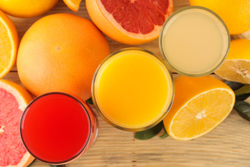 Citrus fruit. various citrus fruits with leaves of lemon, orange, grapefruit and juices on a natural wooden table. top view