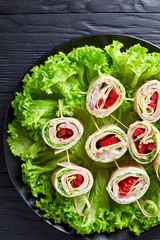 sliced sandwich wraps on a plate, top view