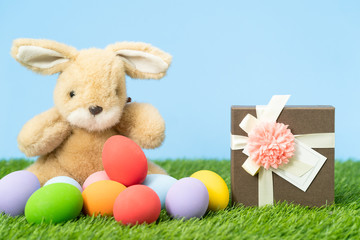 Easter eggs and gift box on grass