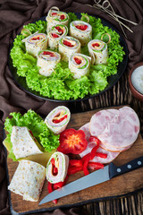 sliced sandwich wraps on a plate, top view
