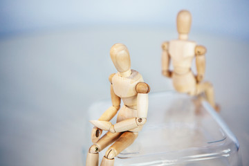Creative concept. Conflict of interest. Wooden men sits on opposite sides.Misunderstanding....