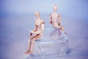 Creative concept. Conflict of interest. Wooden men sits on opposite sides.Misunderstanding....