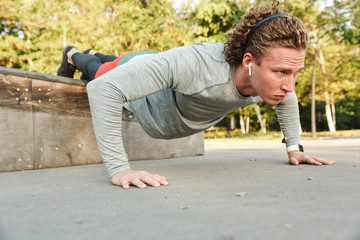 Confident young sportsman doing exercices outdoors