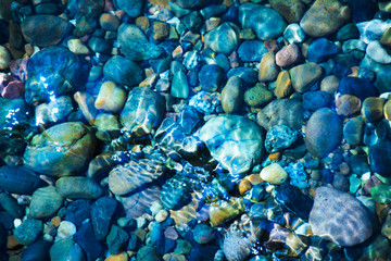 Sea stones in the sea water. Pebbles under water. The view from the top.