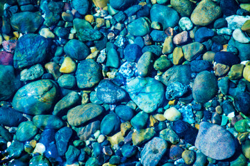 Sea stones in the sea water. Pebbles under water. The view from the top.