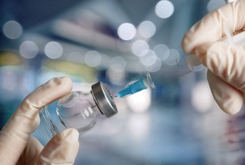 Human Hand with injection Syringe, on  background.