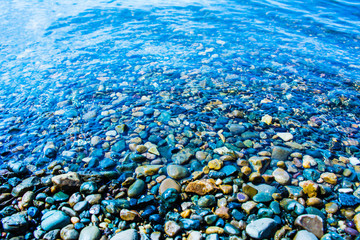 Sea stones in the sea water. Pebbles under water. The view from the top.