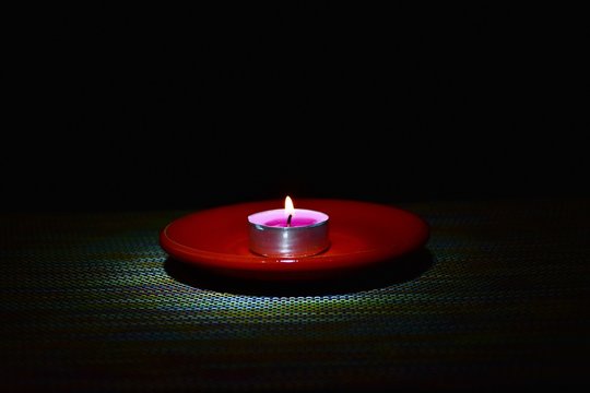 Candlelight On A Red Saucer