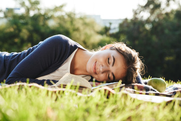 Naklejka na ściany i meble Lovely teenae girl laying on a grass outdoors