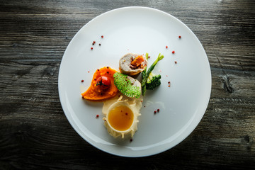 dissected stuffed chicken with pumpkin puree and yellow sauce