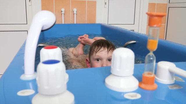 baby boy is taking a bath with bubbles. Jacuzzi bubble bath procedure.