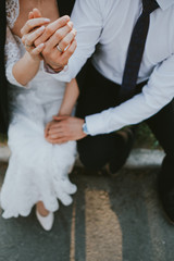 bride and groom holding their hands with rings