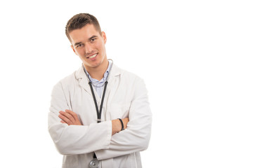 Portrait of young handsome doctor standing with arms crossed