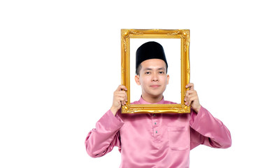 Portrait of young and handsome asian man with traditional clothing holding blank frame over white background