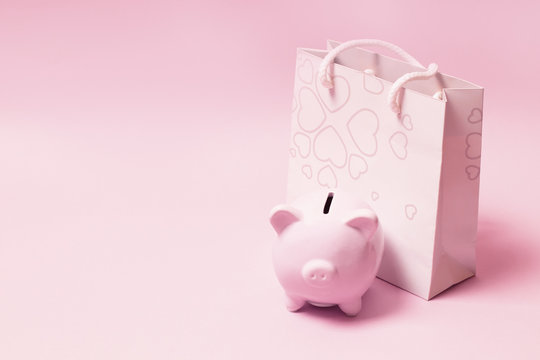 Piggy bank with bag on living coral background. Commercial concept.Top view point, flat lay.