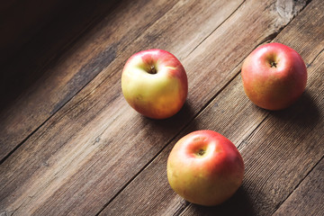 Ripe apples on wooden background.