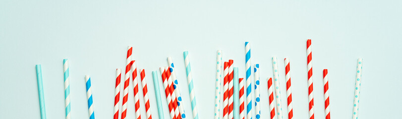 Colorful drinking straws for beverage on a bright background. Birthday festive background.Long wide banner with copy space.