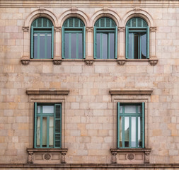 Fototapeta na wymiar Several windows in a row on the facade of the urban historic building front view, Barcelona, Spain