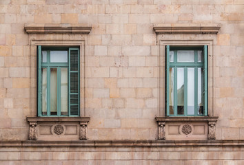 Fototapeta na wymiar Two windows in a row on the facade of the urban historic building front view, Barcelona, Spain