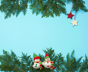 Christmas tree branch on a blue background and two stars with sn