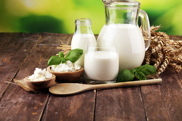 milk products. tasty healthy dairy products on a table. sour cream in a white bowl, cottage cheese bowl, cream in a a bank and milk jar, glass bottle and in a glass