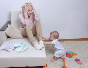 woman sits with her child, postpartum depression