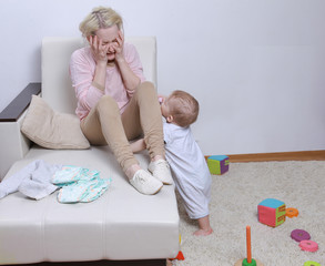 woman sits with her child, postpartum depression