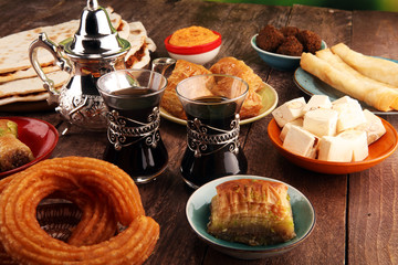 Middle eastern or arabic dishes and assorted meze, concrete rustic background. Turkish Bread or Turkish pizza. Dessert Baklava with pistachio. falafel with hommos.  Halal food. Lebanese cuisine