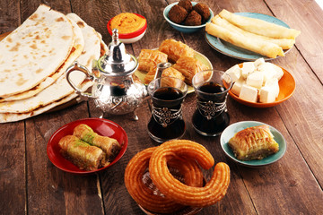 Middle eastern or arabic dishes and assorted meze, concrete rustic background. Turkish Bread or Turkish pizza. Dessert Baklava with pistachio. falafel with hommos.  Halal food. Lebanese cuisine