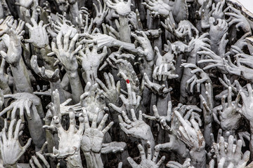 Sculpture of hands reaching from Hell at the entrance to Wat Rong Khun, Chiang Rai, Thailand
