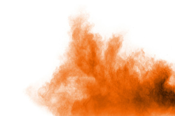 Abstract explosion of orange dust on white background. Freeze motion of orange powder splashing.