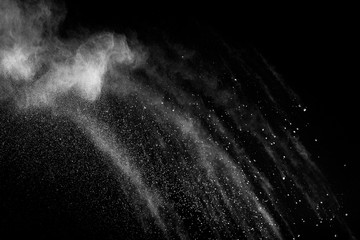 White powder explosion.Freeze motion of white dust particles on black background.