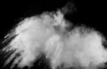 White powder explosion.Freeze motion of white dust particles on black background.