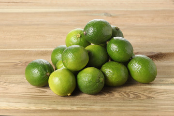 bunch of lime on a wooden table with copy space for your text