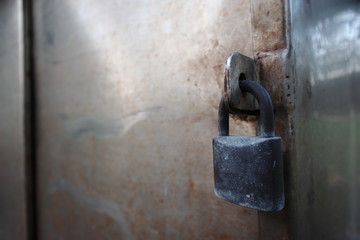 Safety black padlock locked the dirty stainless doors.