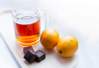 cup of tea with lemon and with chocolate on light background