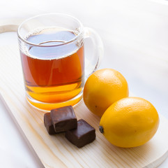 cup of tea with lemon and with chocolate on light background