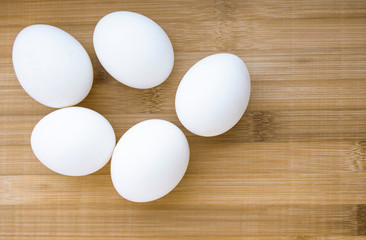 five eggs on wooden background