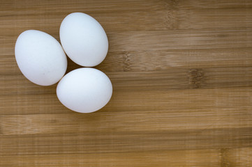 three eggs on wooden background