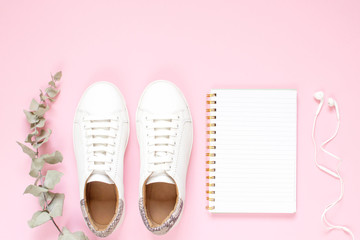 White sneakers on pastel pink background. Flat lay, top view minimal background