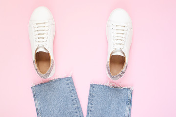 White sneakers on pastel pink background. Flat lay, top view minimal background