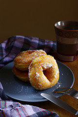 Sugar raised or sugar flavored donuts on a plate and a coffee mug.