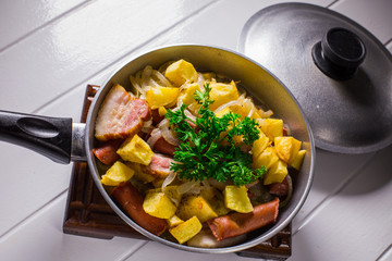 fried egg with sausage and potato in a frying pan