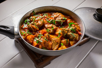 Stuffed meat with potatoes in a tomato sauce on a boiler