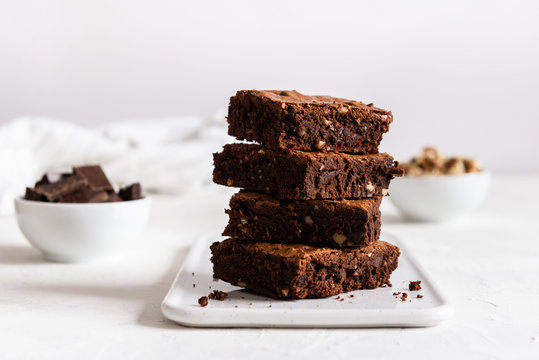 A stack of chocolate brownies on white background, homemade bakery and dessert. Bakery, confectionery concept. Side view